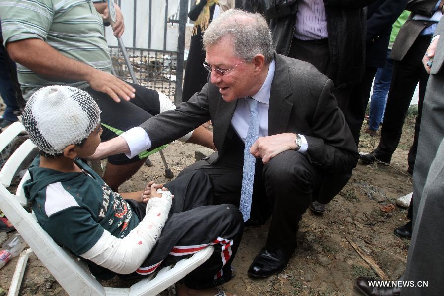 Robert H. Serry, the United Nations special coordinator for the Middle East Peace Process, talks with a wounded Palestinian boy during his visit to Gaza Strip in Gaza City on Nov. 25, 2012. (Photo/Xinhua)