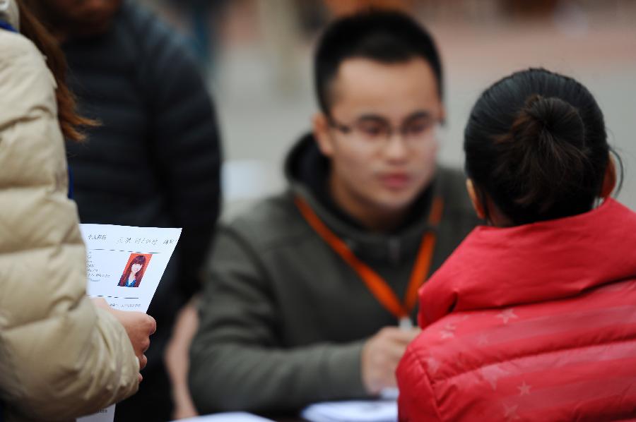 A job hunter (L) holding her resume waits for an interview during a job fair held at Sichuan Normal University in Chengdu, capital of southwest China's Sichuan Province, Nov. 24, 2012. A week-long job hunting fair for college graduates kicked off in Sichuan on Saturday, which provided job vacancies via face-to-face interview and online service. (Xinhua/Li Hualiang) 