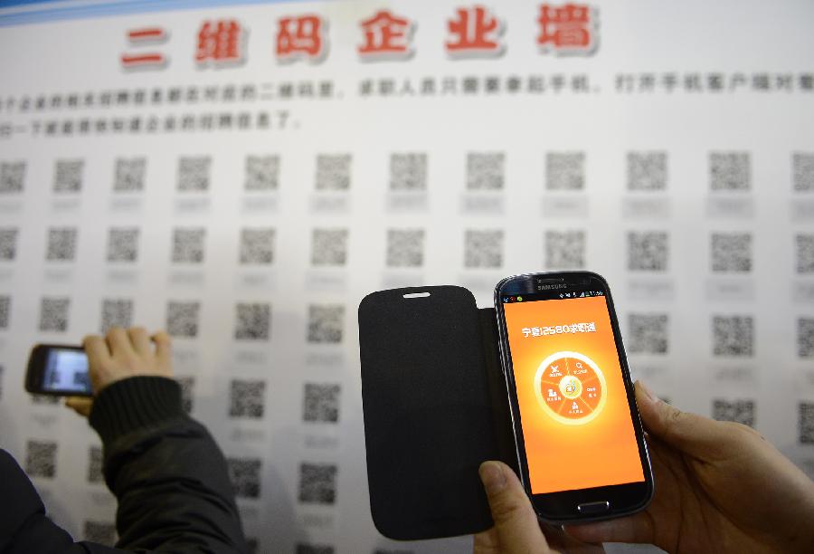 Job seekers scan quick response codes (QR code) with a smartphone to get job information during a job fair in Yinchuan, capital of northwest China's Ningxia Hui Autonomous Region, Nov. 24, 2012. The host of the job fair provided QR codes for the convenience of job seeker.(Xinhua/Wang Peng)