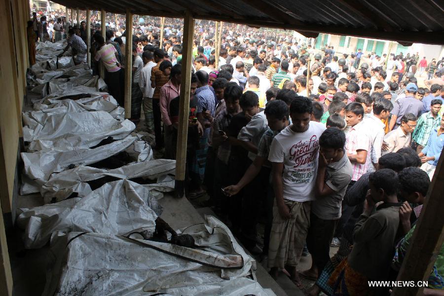 Relatives identify bodies near a garment factory where a fire broke out in Saver, outskirts of Dhaka, Bangladesh, Nov. 25, 2012. It is believed that over 100 people died in the accident, said the police. (Xinhua/Shariful Islam) 