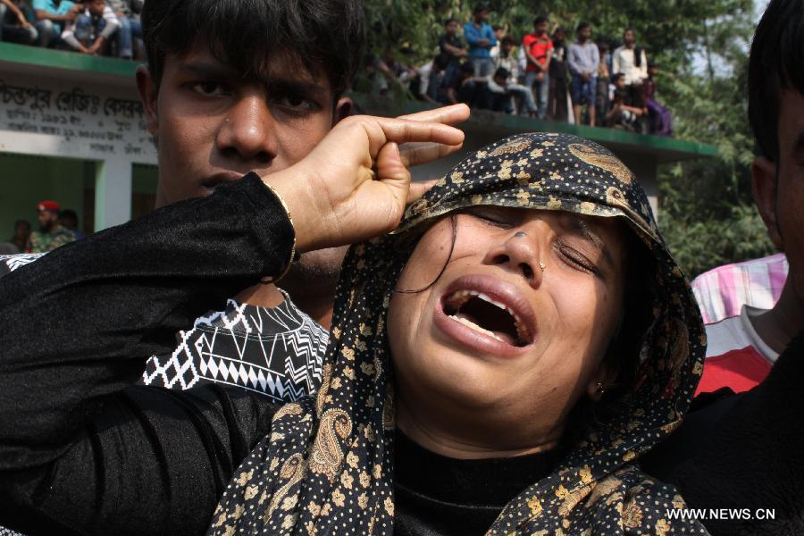 A woman cries over the loss of her husband after a fire accident in a garment factory in Saver, outskirts of Dhaka, Bangladesh, Nov. 25, 2012. It is believed that over 100 people died in the accident, said the police.(Xinhua/Shariful Islam) 
