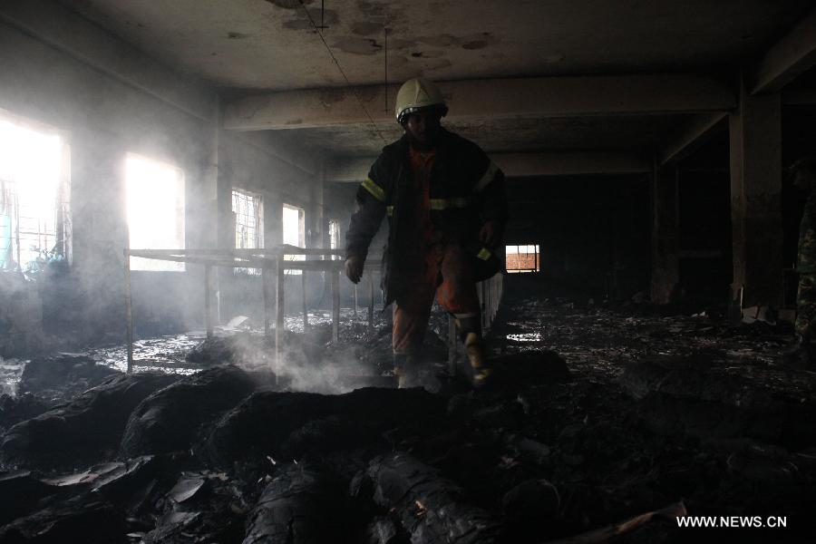 A firefighter searches bodies after a fire accident at a garment factory in Saver, outskirts of Dhaka, capital of Bangladesh, Nov. 25, 2012. It is believed that over 100 people died in the accident, said the police. (Xinhua/Shariful Islam)