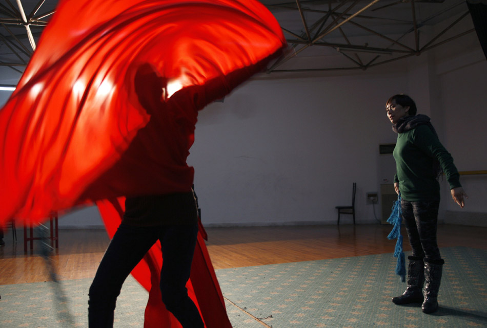 Wu Fenghua (R) gives instructions to her student Zhang Qingqing in Xiaobaihua Shaoxing Opera Troupe in Shaoxing, east China's Zhejiang Province, Dec. 10, 2011. (Xinhua/Cui Xinyu)