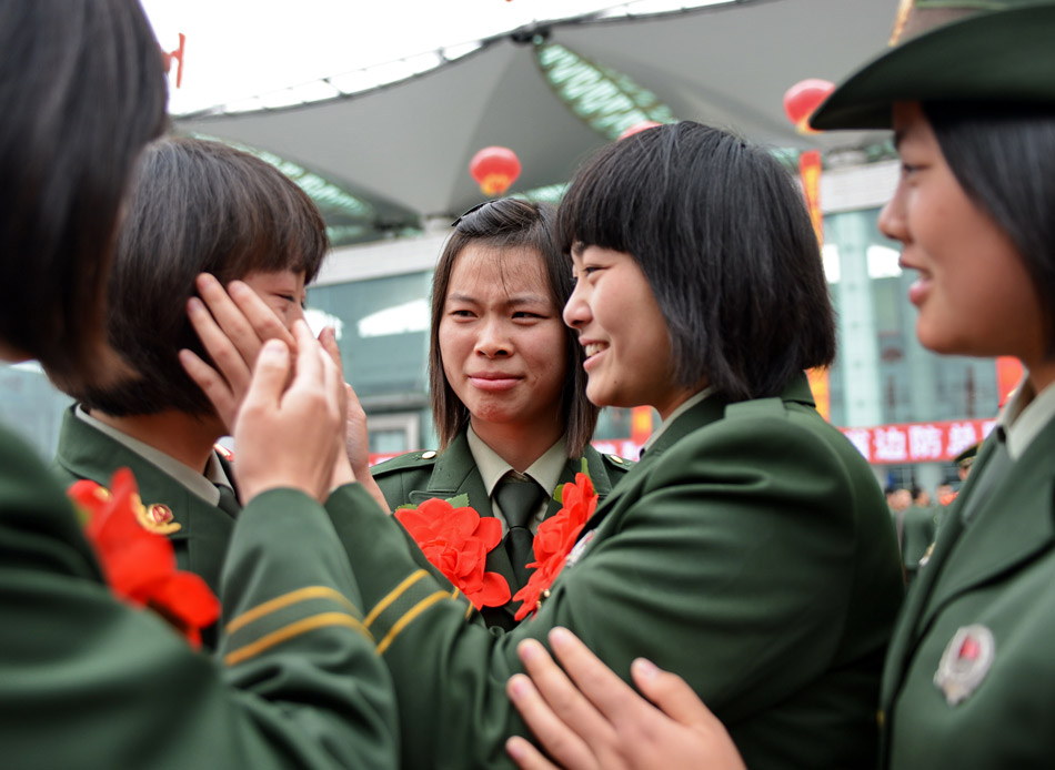 Cheng Haiyan (2nd from right), a veteran to be discharged from active duty from Fuzhou Public Security Frontier Detachment, wipes her comrade’s tears on Nov. 25, 2012. The veterans discharged from the Fujian border public security force bid farewell to their comrades and set foot on their way home. (Xinhua/Zhang Guojun)