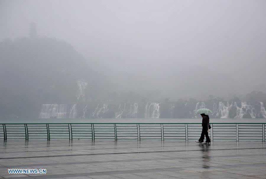 Citizens walk in the fog-shrouded Liuzhou City, southwest China's Guangxi Zhuang Autonomous Region, Nov. 25, 2012. (Xinhua/Li Hanchi) 
