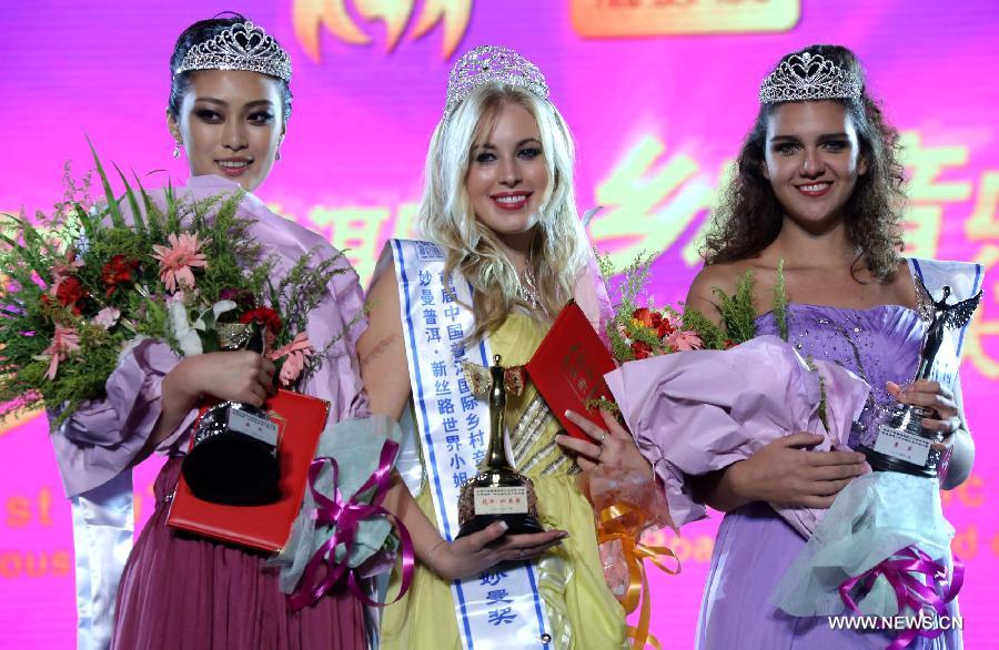 Top winner Emily Dorma (C) from Canada, runner-up Teng Tianyue (L) from China and the second runner-up Rhanna Mayara from Brazil pose for group photos at an awarding ceremony of the New Silk Road Miss World Competition in Pu'er, southwest China's Yunnan Province, Nov. 24, 2012. A total of 46 models from across the world competed in the finals of the contest. (Xinhua/Li Mingfang) 
