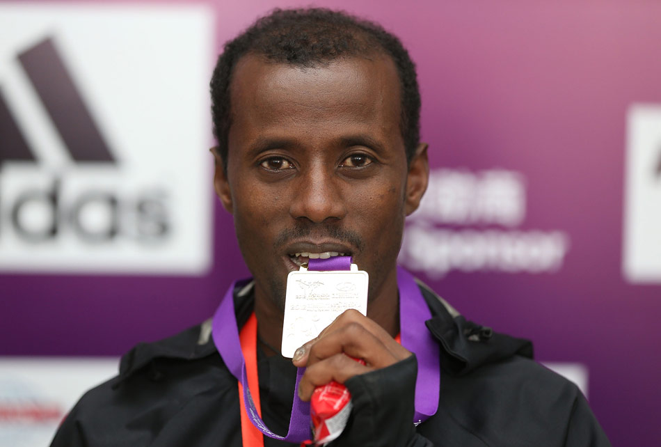 Ethiopian runner Tariku Jufar Robi shows his gold medal at the press conference on Nov. 25, 2012. Tariku Jufar Robi won the title of the 2012 Beijing International Marathon with the results of 2:09:39. (Xinhua/Liao Yujie)