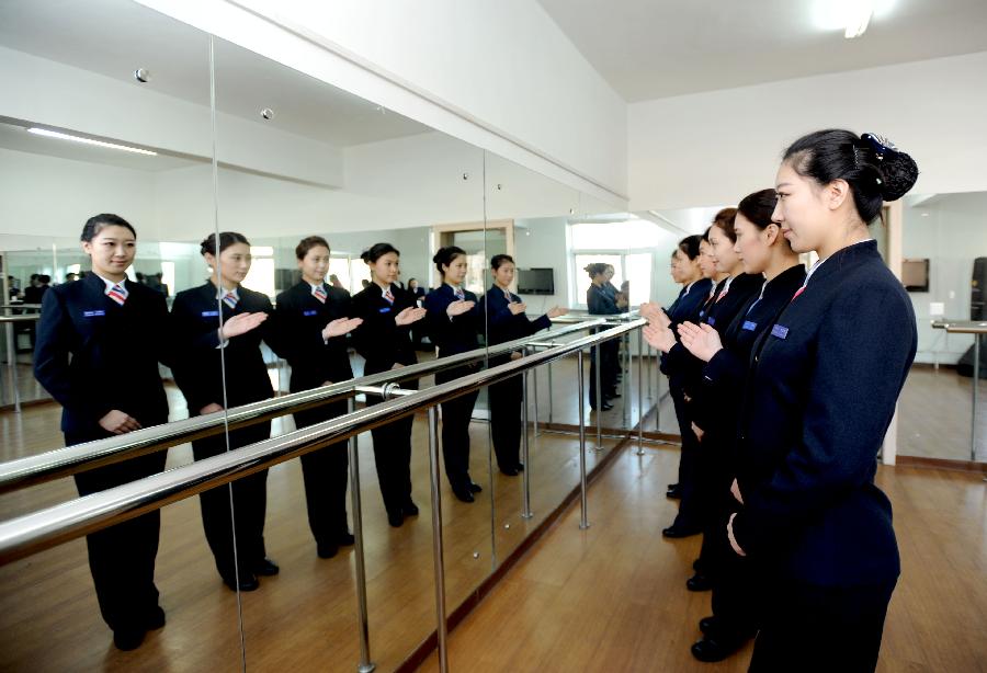 Bullet train attendants attend an etiquette class in preparation for the opening of the Harbin-Dalian High-Speed Railway in Shenyang, capital of northeast China's Liaoning Province, Nov. 26, 2012. The Shenyang Railway Bureau has launched training programmes for bullet train attendants who will be working on the Harbin-Dalian High-Speed Railway, scheduled to open on Dec. 1, 2012. The 921-km Harbin-Dalian High-Speed Railway is the first rail line in China's freezing high-latitude regions. (Xinhua/Zhang Wenkui) 