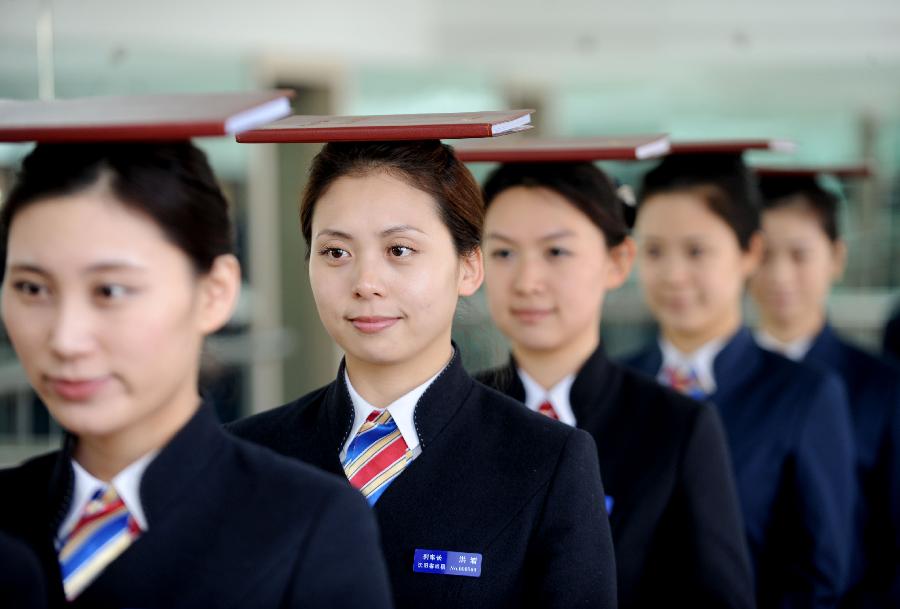 Bullet train attendants attend an etiquette class in preparation for the opening of the Harbin-Dalian High-Speed Railway in Shenyang, capital of northeast China's Liaoning Province, Nov. 26, 2012. The Shenyang Railway Bureau has launched training programmes for bullet train attendants who will be working on the Harbin-Dalian High-Speed Railway, scheduled to open on Dec. 1, 2012. The 921-km Harbin-Dalian High-Speed Railway is the first rail line in China's freezing high-latitude regions. (Xinhua/Zhang Wenkui) 