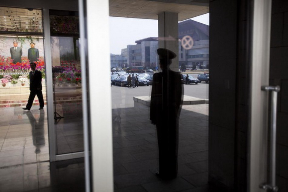 The figure of a security guard in the window. He stood at the entrance to a hall where a flower exhibition was held. (Photo/Xinhua)