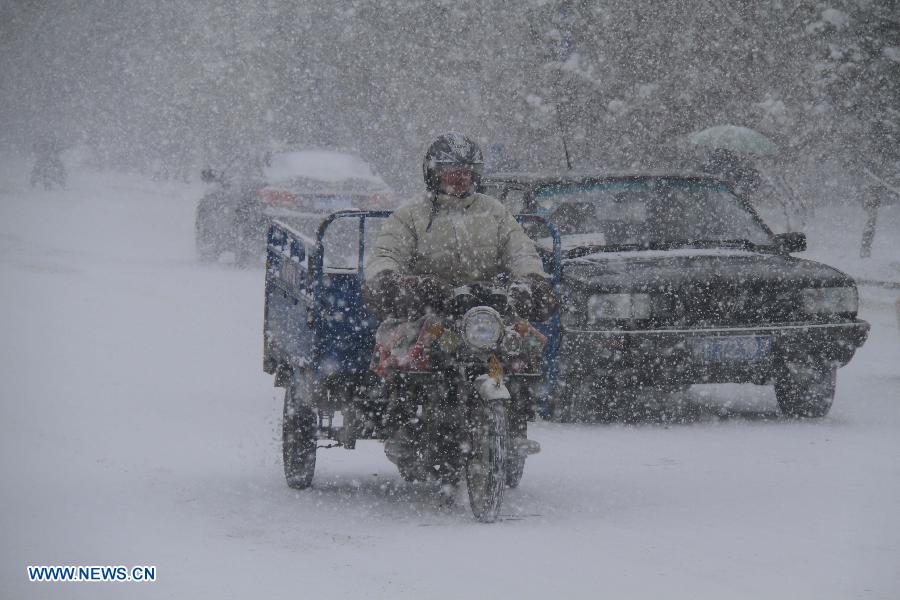 Vehicles ride in the snow on a street in Altay, northwest China's Xinjiang Uygur Autonomous Region, Nov. 26, 2012. Heavy snow hit Altay since last Monday, bringing inconveniences to the herdsmen and traffic here. (Xinhua/Tang Xiaobo) 