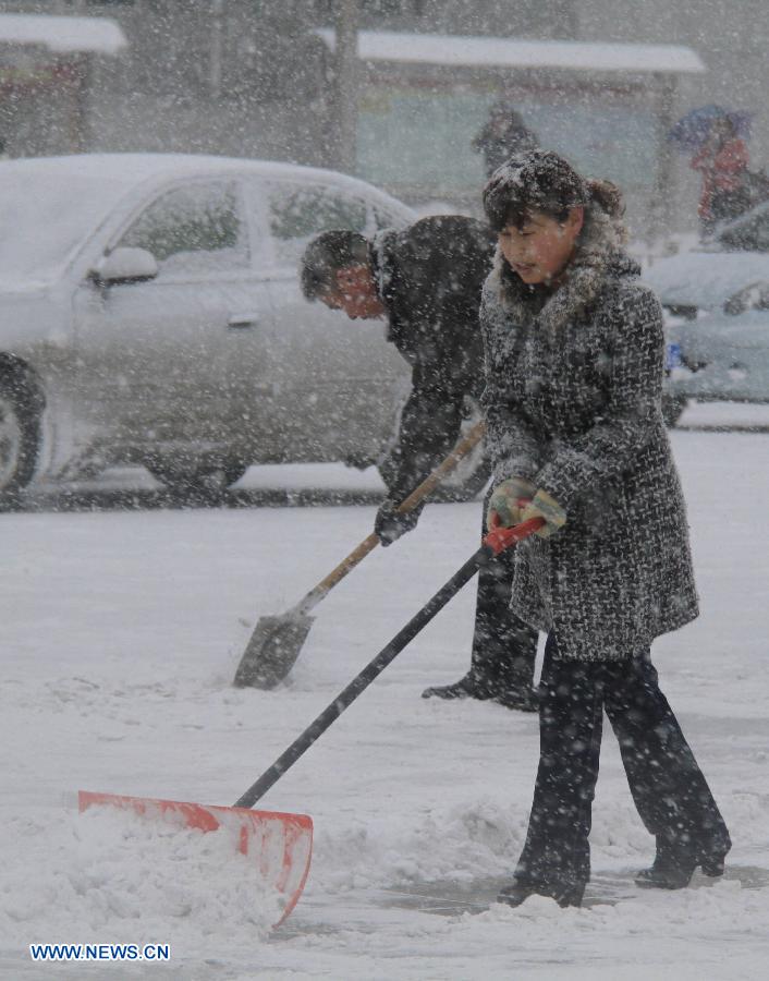 Citizens sweep the accumulated snow in Altay, northwest China's Xinjiang Uygur Autonomous Region, Nov. 26, 2012. Heavy snow hit Altay since last Monday, bringing inconveniences to the herdsmen and traffic here. (Xinhua/Tang Xiaobo) 