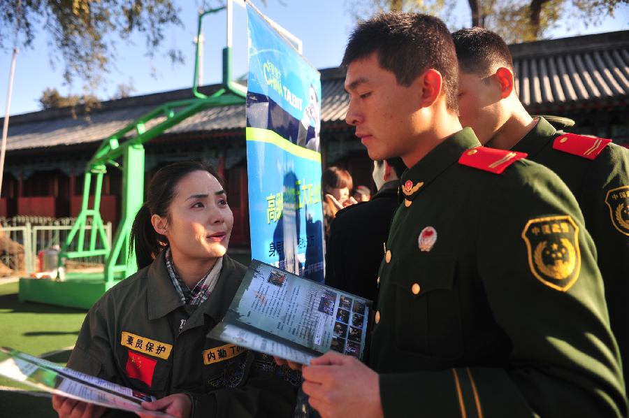 An employer introduces her company to veterans of Chinese national flag escort in Beijing, capital of China, Nov. 23, 2012. More than 40 companies came to the escort to employ the demobilized veterans on Friday. (Xinhua/Liu Changlong) 