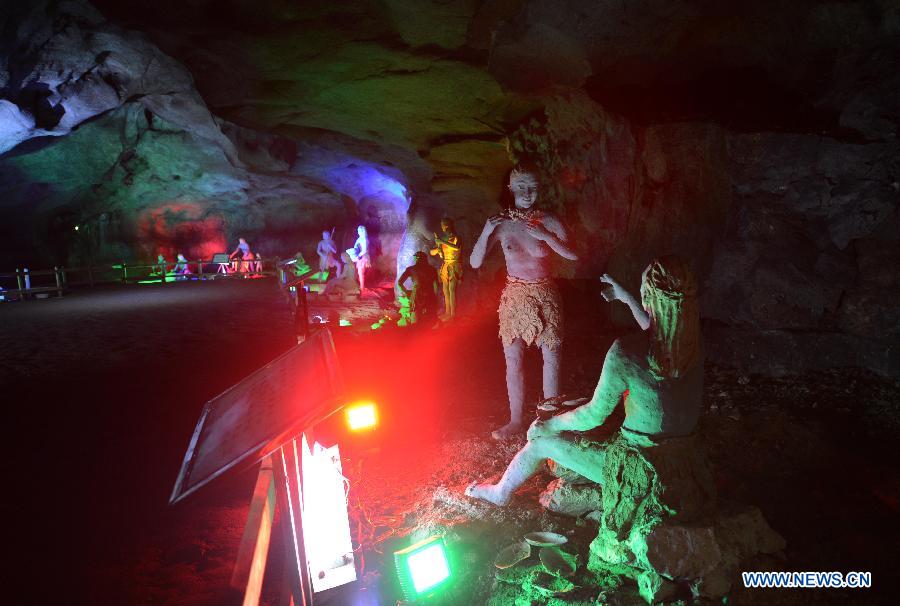 Photo taken on Nov. 26, 2012 shows the sculptures imitating ancient people's life at the Xianren Cave in Dayuan Township of Wannian County, east China's Jiangxi Province. Xianren Cave is the location for historically important finds of prehistoric pottery sherds and rice remains. (Xinhua/Zhou Ke) 