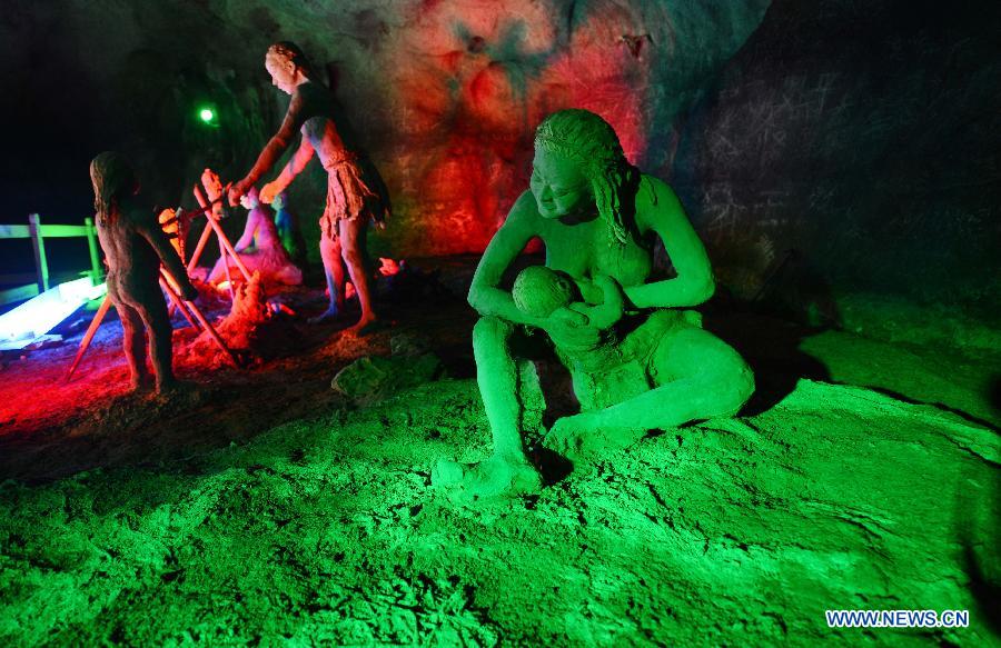 Photo taken on Nov. 26, 2012 shows the sculptures imitating ancient people's life at the Xianren Cave in Dayuan Township of Wannian County, east China's Jiangxi Province. Xianren Cave is the location for historically important finds of prehistoric pottery sherds and rice remains. (Xinhua/Zhou Ke) 