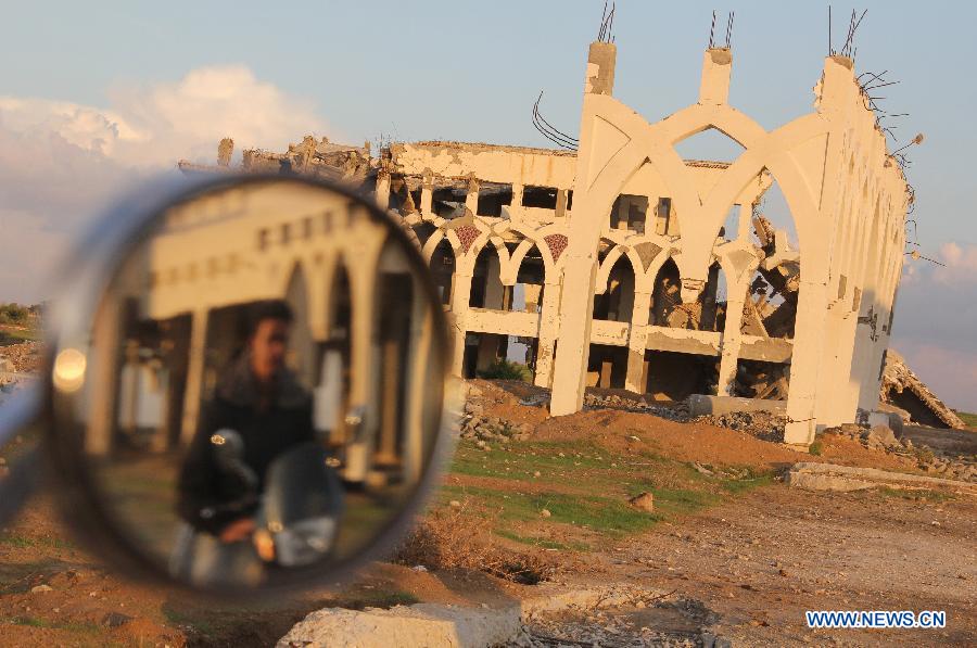 A reflection of a Palestinian motorbike rider is seen at the rubble of the Gaza International Airport in the southern Gaza Strip city of Rafah, on Nov. 25, 2012. (Xinhua/Khaled Omar) 
