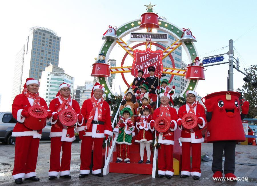 South Korean people wearing Santa Claus costumes pose for photos during a fundraising campaign ceremony in Seoul, South Korea, Nov. 26, 2012. (Xinhua/Park Jin-hee) 