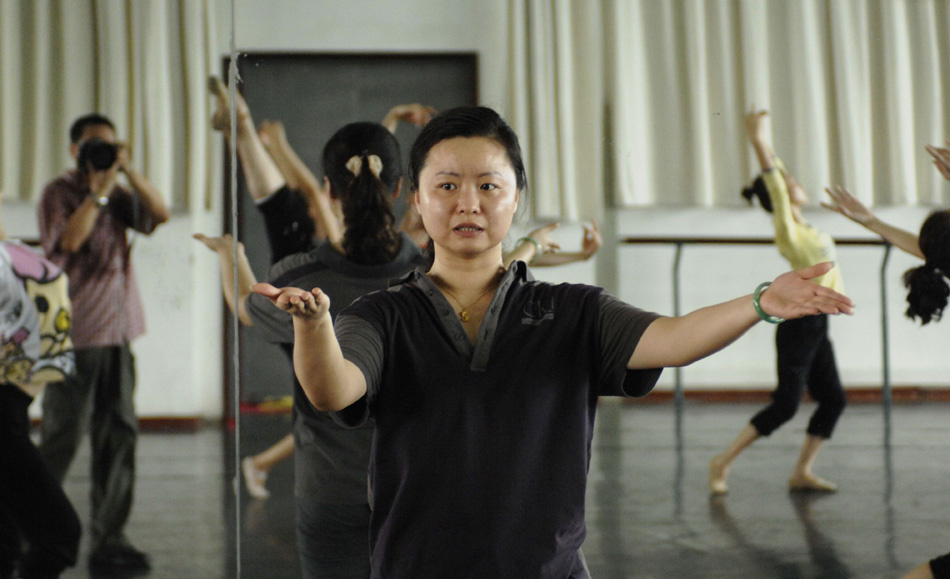 Director and choreographer Tong Ruirui (C) instructs performers during the rehearsal of the dance drama Goddess And The Dreamer in Zhengzhou, capital of central China's Henan Province, Aug. 4, 2010. (Xinhua/Ye Jin)