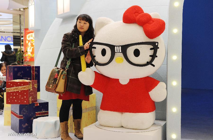 A woman poses for pictures with a red Hello Kitty in the Joy City in east China's Shanghai Municipality, Nov. 26, 2012. A big Hello Kitty exhibition themed on Hello Kitty's exploration in the polar regions would last from Nov. 24, 2012 to Feb. 24, 2013 in Shanghai. (Xinhua/Lai Xinlin) 