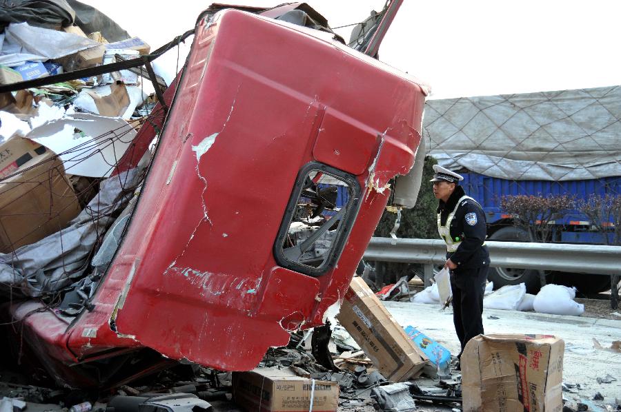A police officer examines a damaged vehicle at a traffic accident scene on the Tai'an section of the Beijing-Taipei Expressway in Tai'an, east China's Shandong Province, Nov. 26, 2012. Seven people died and 35 others were injured in at least 22 accidents on several sections of an expressway in Shandong Province amid heavy fog on Monday, local government officials said. Seven crashes occurred on the Tai'an section of the Beijing-Taipei Expressway early Monday morning, leaving one dead and eleven injured, while 15 crashes occurred on the expressway's Ningyang section, killing six and injuring another 24, the traffic police reported. By Monday afternoon, police said the expressways had reopened. (Xinhua/Xu Suhui) 