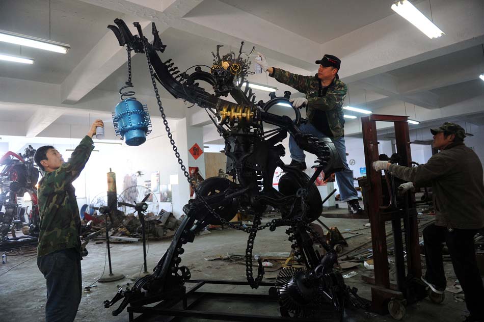 Artist Zhu Kefeng (C) creates a steel artwork along with his colleagues at the Mr. Iron Robot Theme Park in Jiaxing, east China's Zhejiang Province, March 24, 2012. (Xinhua/Xu Yu) 