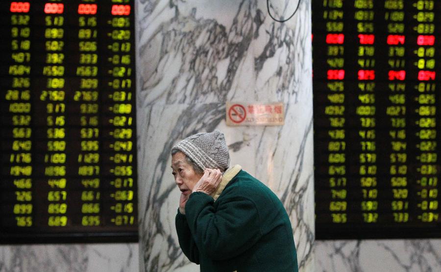 An investor is seen in front of an electronic board showing stock information at a stock trading hall in Shanghai, east China, Nov. 27, 2012. Chinese stocks continued to fall Tuesday, with the benchmark Shanghai Composite Index dipping 1.3 percent, or 26.3 points, to end at 1,991.17, the lowest level since February 2009. The Shenzhen Component Index closed at 7,936.74, down 79.33 points, or 0.99 percent. (Xinhua/Pei Xin)