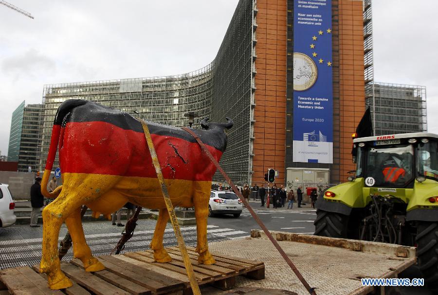 Dairy farmers drive tractors past the European Commission to the European Parliament to stage a protest against EU agricultural policies in Brussels, capital of Belgium, on Nov. 26, 2012. Dairy farmers from all over Europe demonstrated today with about 1,000 tractors at the European Parliament in Brussels to protest against falling milk prices caused by overproduction in the continent. (Xinhua/Zhou Lei) 