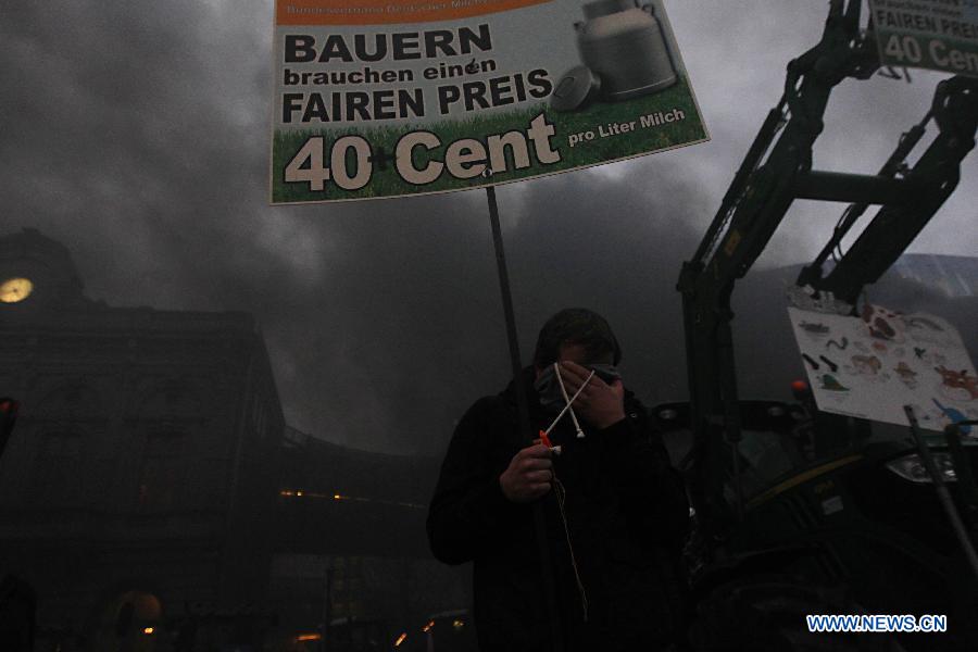 A dairy farmer covers his face after getting pepper-sprayed by the police during a protest against EU agricultural policies at the Place du Luxembourg, outside the European Parliament in Brussels, capital of Belgium, on Nov. 26, 2012. Dairy farmers from all over Europe demonstrated today with about 1,000 tractors at the European Parliament in Brussels to protest against falling milk prices caused by overproduction in the continent. (Xinhua/Zhou Lei) 