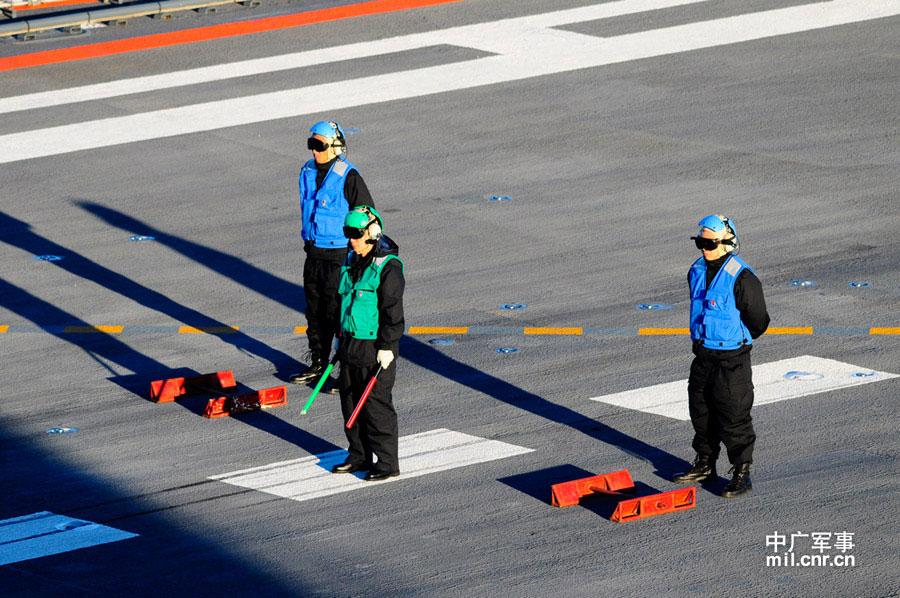 Photo shows crew members of China's first aircraft carrier, the Liaoning, wearing waistcoats of different colors, which indicate their different works. (mil. cnr.cn/ Sun Li)