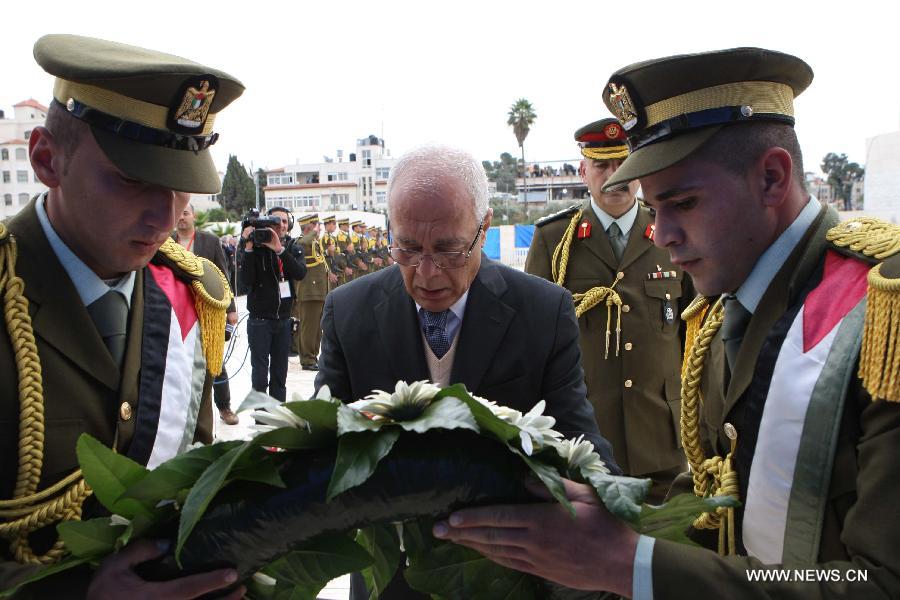 Tayeb Abdel Rahim (C), secretary-general of the Palestinian presidency, places a wreath at the tomb of late Palestinian leader during a ceremony in the West Bank city of Ramallah, on Nov. 27, 2012. Samples of the remains of iconic Palestinian leader Yasser Arafat were exhumed so experts could search for additional clues to his death, Palestinian officials said. (Xinhua/POOL)