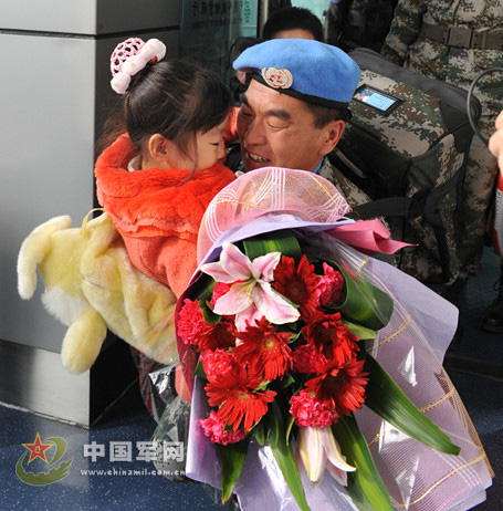 Zhang Jian, who is a master sergeant, 4th class, hugs his daughter at the airport on Nov. 24, 2012. The 100 Chinese peacekeepers who are the third batch of the first Chinese peacekeeping contingent to South Sudan returning to China arrive at the Xinzheng International Airport in central China's Henan province by air last Saturday. (PLA Daily/Zhang Zhe)