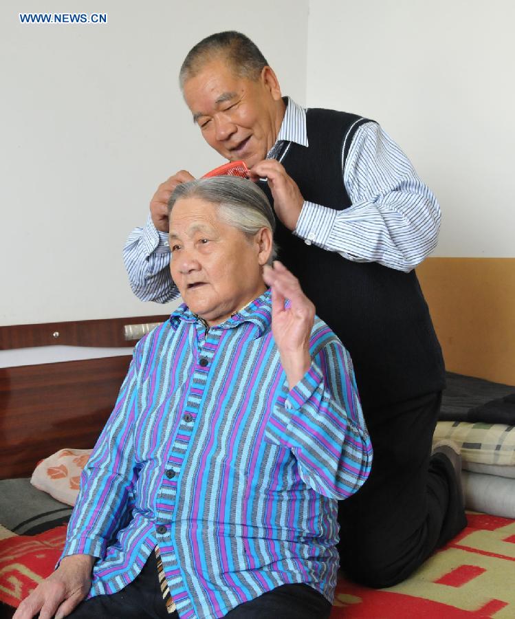 Zhu Qingzhang combs his adoptive mother Han Fuzhen's hair at home in Baotou, north China's Inner Mongolia Autonomous Region, Nov. 27, 2012. An accident left Zhu Qingzhang's adoptive mother Han Fuzhen in a vegetative state in 1975. Since then, Zhu has been looking after his adoptive mother while doing his own job. And all his love for his adoptive mother paid off when Han finally woke up 31 years later. Under the care of 62-year-old Zhu, 86-year-old Han now lives a happy and healthy life. (Xinhua/Liu Yide) 