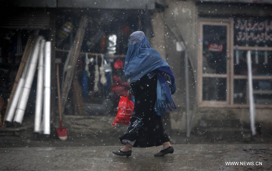 An Afghan woman walks on a road on a snowy day in Kabul, capital of Afghanistan, on Nov. 28, 2012. Kabul witnessed the first snow of the season on Wednesday. (Xinhua/Ahmad Massoud)