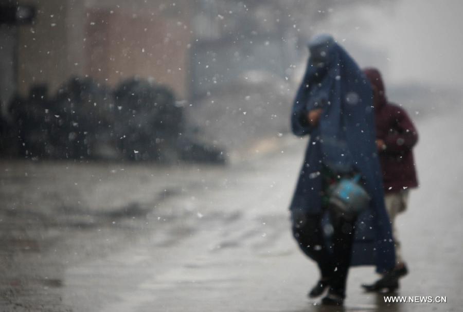 People walk on a road on a snowy day in Kabul, capital of Afghanistan, on Nov. 28, 2012. Kabul witnessed the first snow of the season on Wednesday. (Xinhua/Ahmad Massoud)