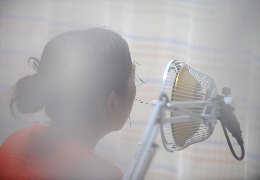 A woman receives acupuncture in Taiyuan, capital of north China's Shanxi Province, Nov. 23, 2012. More and more Chinese are disposed to preventive treatment of discease rather than curative treatment, they receive acupuncture, moxibustion, herbal paste or other Chinese traditional regimen to improve sub-healthy state.(Xinhua/Yan Yan) 