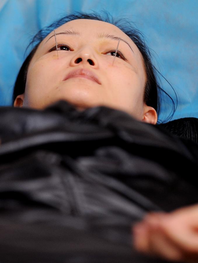 A woman receives acupuncture in Taiyuan, capital of north China's Shanxi Province, Nov. 23, 2012. More and more Chinese are disposed to preventive treatment of discease rather than curative treatment, they receive acupuncture, moxibustion, herbal paste or other Chinese traditional regimen to improve sub-healthy state.(Xinhua/Yan Yan) 