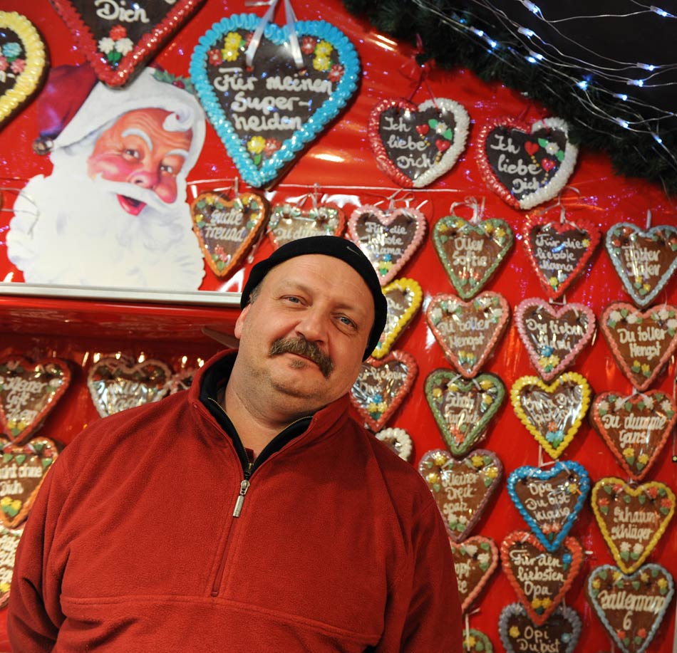 A shopkeeper sells heart-shaped gingerbread, the traditional Christmas food, in the Christmas market at the Charlottenburg Palace, Berlin, capital of Germany, on Nov. 26, 2012. Since the Western traditional holiday Christmas is approaching, Christmas markets have opened one after another in Berlin. (Xinhua/Ban Wei)