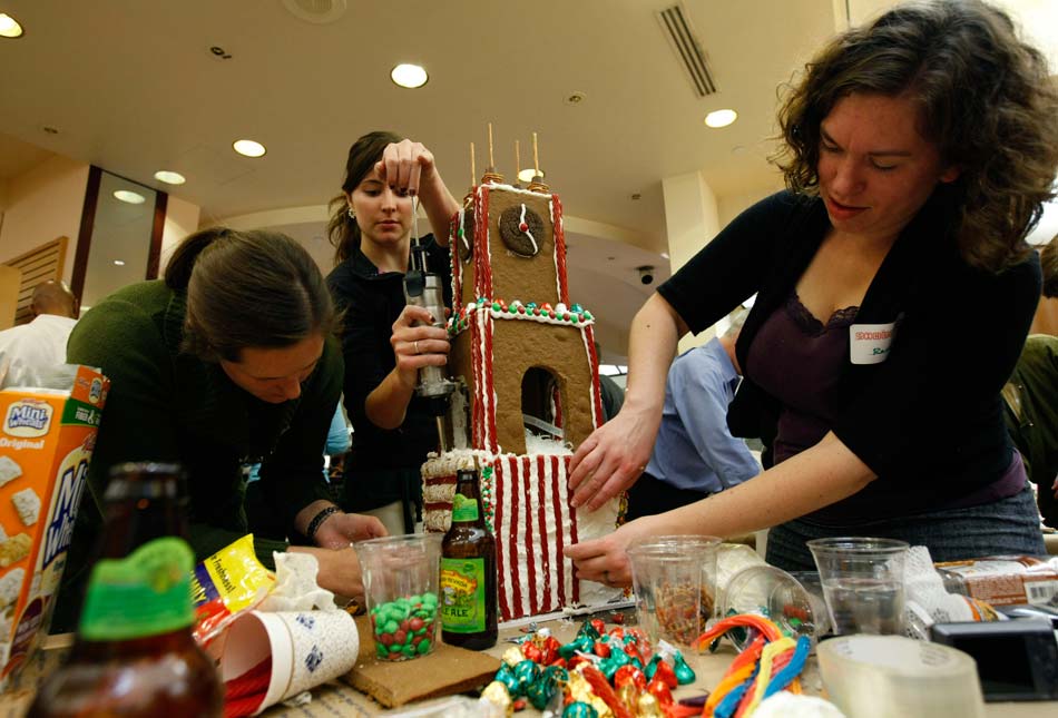 People build the “bell tower”, the tallest building in “gingerbread village”, in Washington D. C., capital of the United States, on Nov. 26, 2012. The “gingerbread village” was proposed to build by an architect in 2006.  Since then, architects and designers in the capital gather annually to build a village composed of gingerbread to celebrate the Christmas. (Xinhua/Fang Zhe)