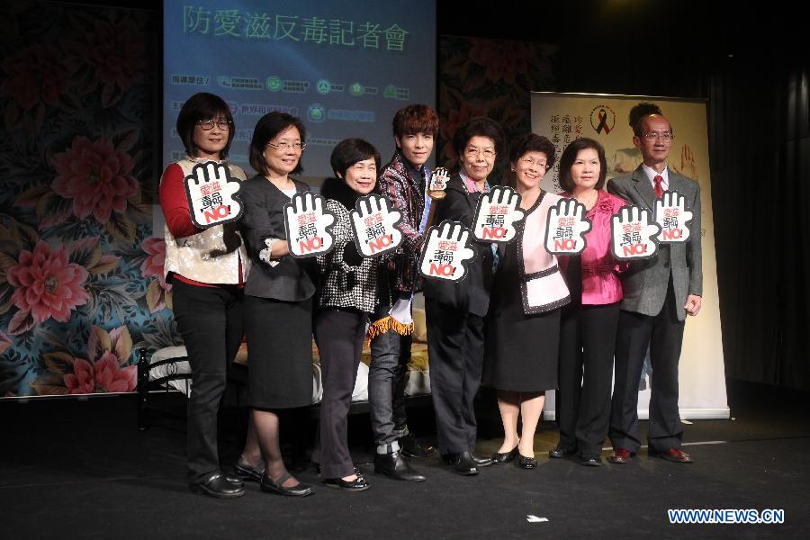 Pop singer Jam Hsiao (4th L) poses with anti-AIDS and anti-drugs activists at a press conference promoting his new album "It's All About Love" in Taipei, southeast China's Taiwan, Nov. 28, 2012. (Xinhua/Xing Guangli) 