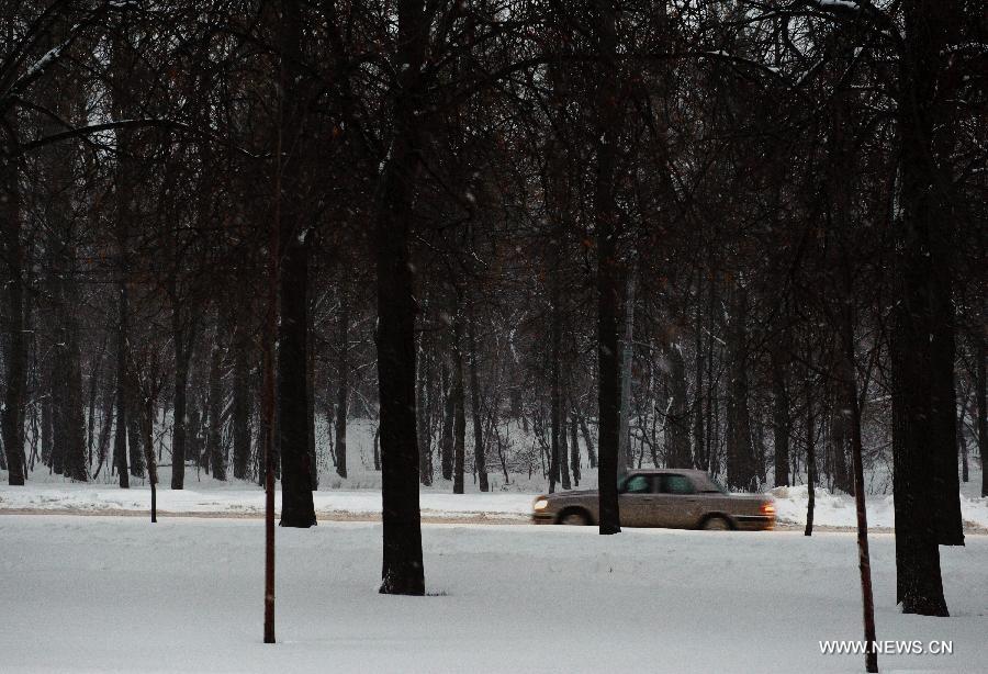 Vehicles move on a snow-covered road in Moscow, capital of Russia, on Nov. 29, 2012. A heaviest snow of the season hit Moscow Wednesday and snow on the ground has accumulated to about 20-cm deep Thursday. (Xinhua/Jiang Kehong)