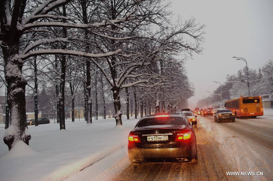 Vehicles move on a snow-covered road in Moscow, capital of Russia, on Nov. 29, 2012. A heaviest snow of the season hit Moscow Wednesday and snow on the ground has accumulated to about 20-cm deep Thursday. (Xinhua/Jiang Kehong)