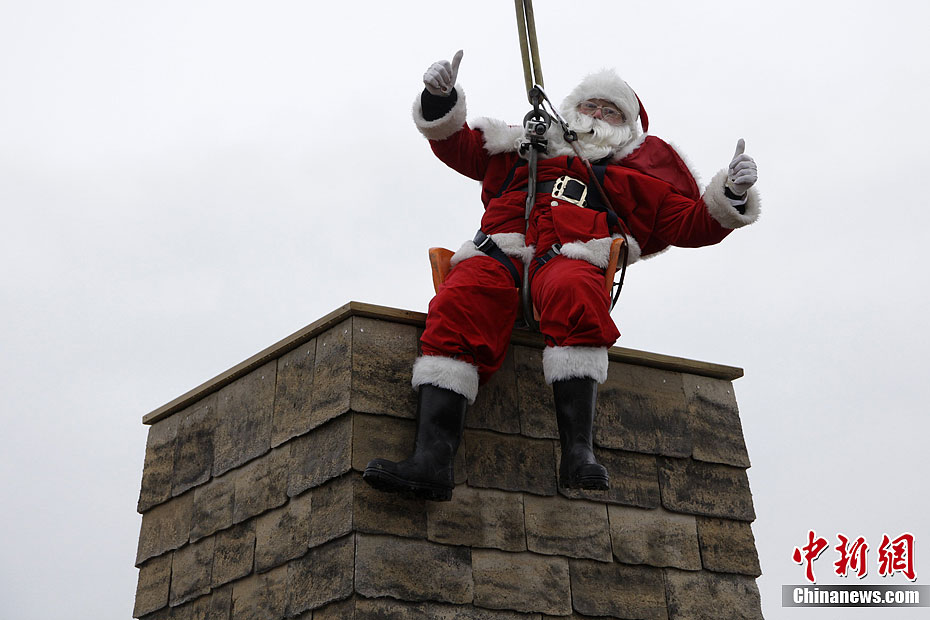 A “Santa Claus” from south England intends to climb through the chimney, Dec. 19, 2011. (Photo/ Chinanews.com)