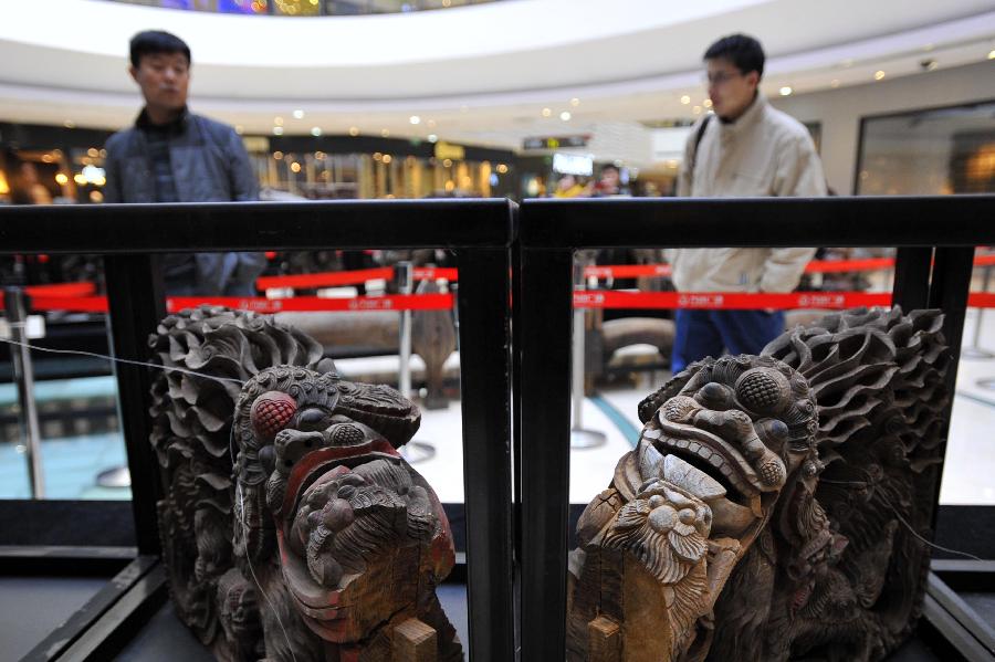 People visit an exhibition of ancient Chinese architectural woodcarving components in Jinan, capital of east China's Shandong Province, Nov. 29, 2012. (Xinhua/Guo Xulei)