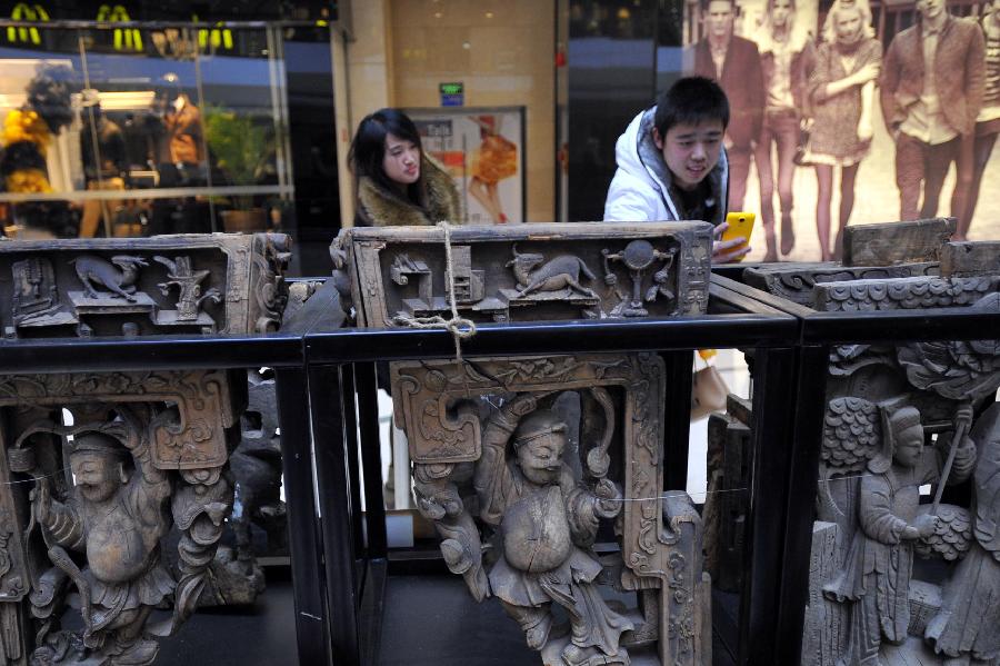 People visit an exhibition of ancient Chinese architectural woodcarving components in Jinan, capital of east China's Shandong Province, Nov. 29, 2012.  (Xinhua/Guo Xulei)