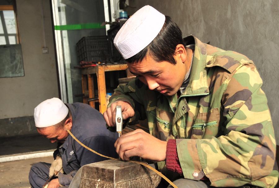 Craftsmen of China's Bao'an ethnic group make parts of broadswords in Jishishan County, northwest China's Gansu Province, Nov. 29, 2012.  (Xinhua/Huang Wenxin) 