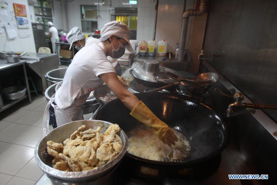 A worker prepares students' lunch at the dining hall of Dajia Elementary School in Taipei, southeast China's Taiwan, Nov. 29, 2012. Food metarials are purchased through bidding in order to make sure of the nutrition, low price and taste of lunch for students. (Xinhua/Xing Guangli) 