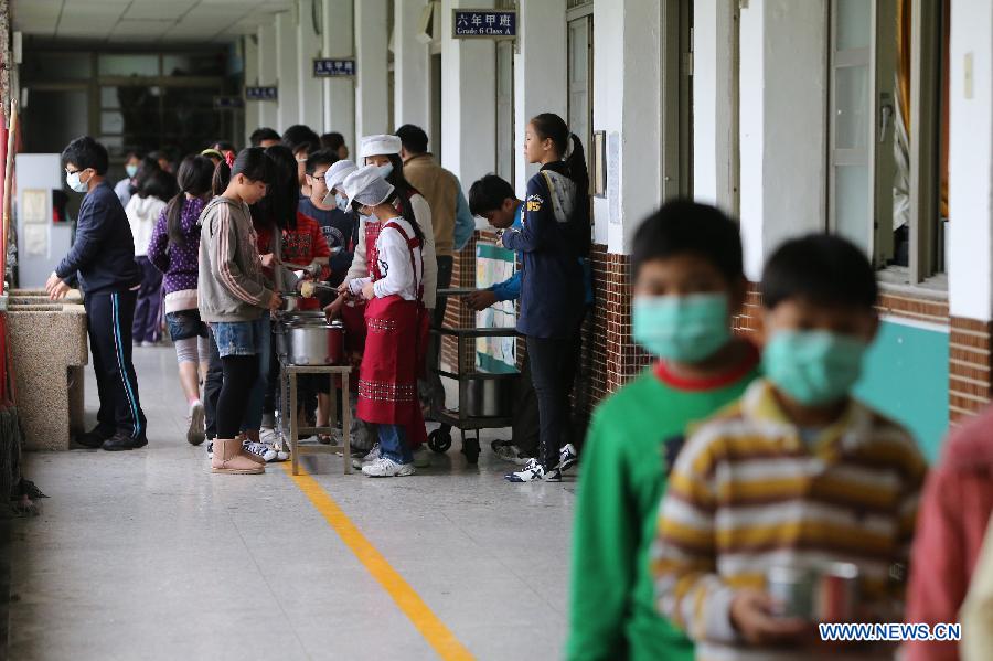 Students of Dajia Elementary School wait in line to get their lunch in Taipei, southeast China's Taiwan, Nov. 29, 2012. Food metarials are purchased through bidding in order to make sure of the nutrition, low price and taste of lunch for students. (Xinhua/Xing Guangli) 