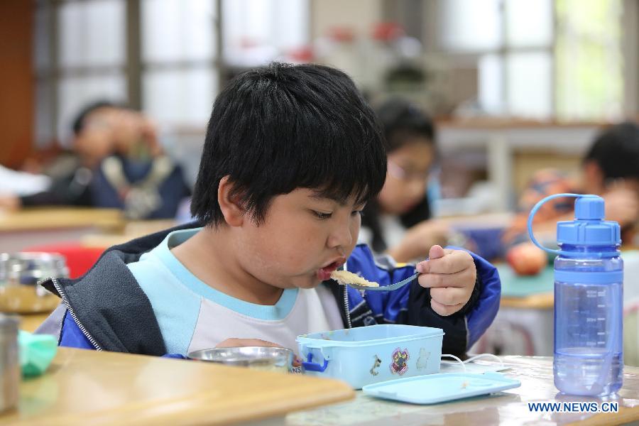 Students of Dajia Elementary School enjoy their lunch in Taipei, southeast China's Taiwan, Nov. 29, 2012. Food metarials are purchased through bidding in order to make sure of the nutrition, low price and taste of lunch for students. (Xinhua/Xing Guangli) 