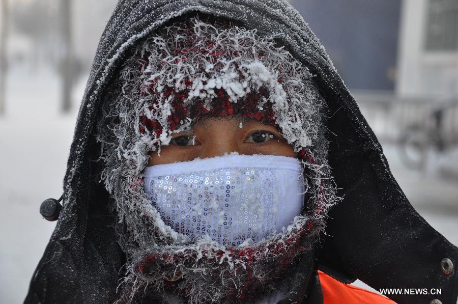 A sanitation worker is seen with ice on head in Hulun Buir, north China's Inner Mongolia Autonomous Region, Nov. 29, 2012. Snowfall and temperature drop hit the city these days. (Xinhua/Yu Changjun) 