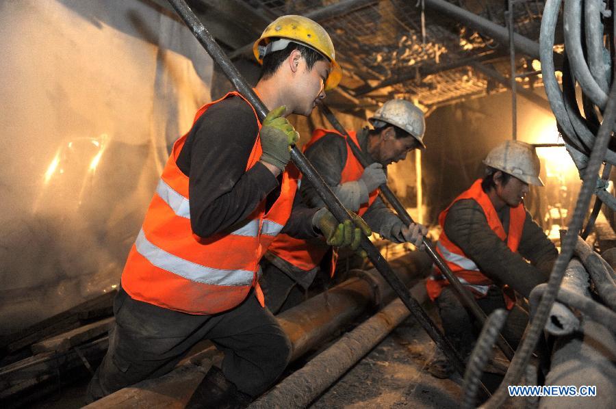 Laborers work in the Zhaobishan Tunnel of the second line of Lanxin (Lanzhou-Xinjiang) Railway in Datong County, northwest China's Qinghai Province, Nov. 27, 2012. 